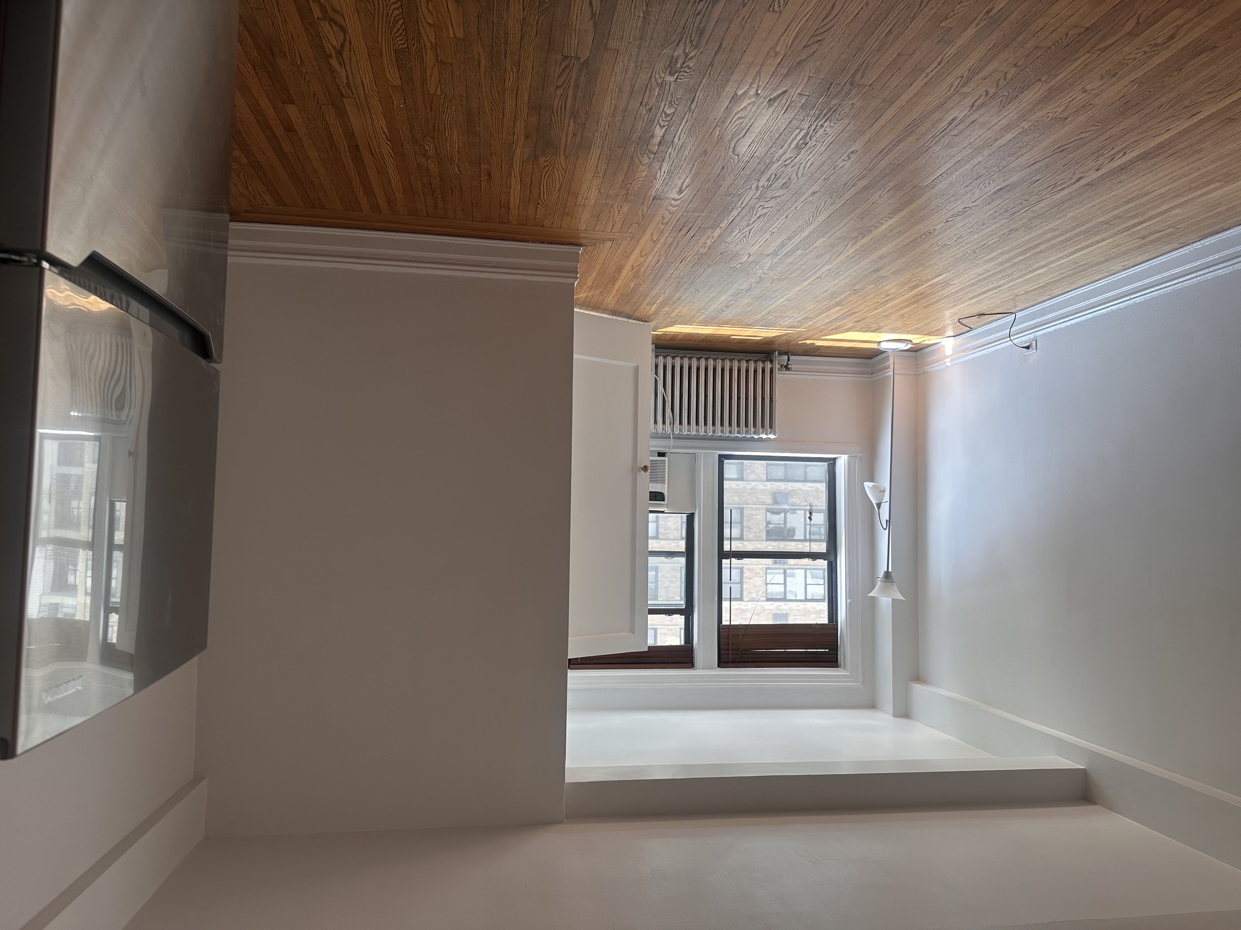 457 West 57th Street, Unit 505 Manhattan, NY 10019 - Photo 4 of 10 an empty room with wooden floor and windows