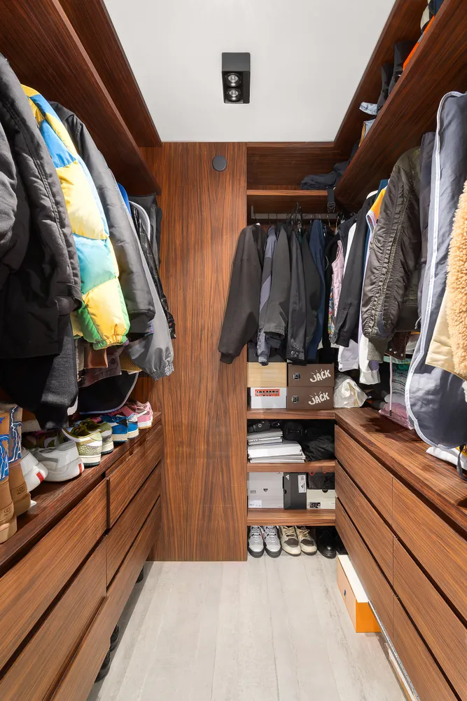 a view of walk in closet with clothes and shoes