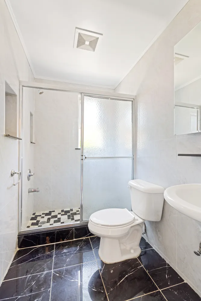 a bathroom with a toilet a sink and a shower