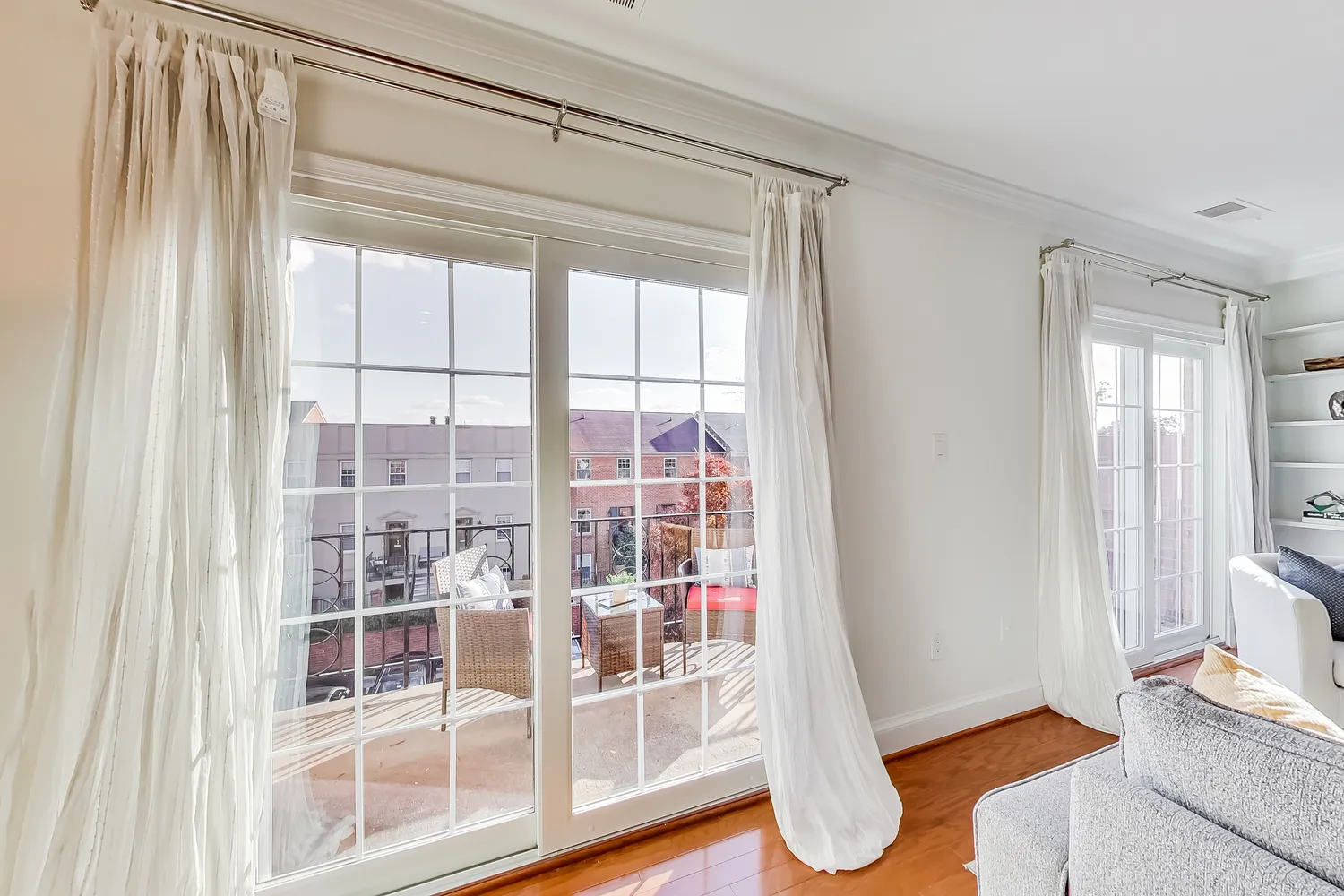 a living room with wooden floor and floor to ceiling windows