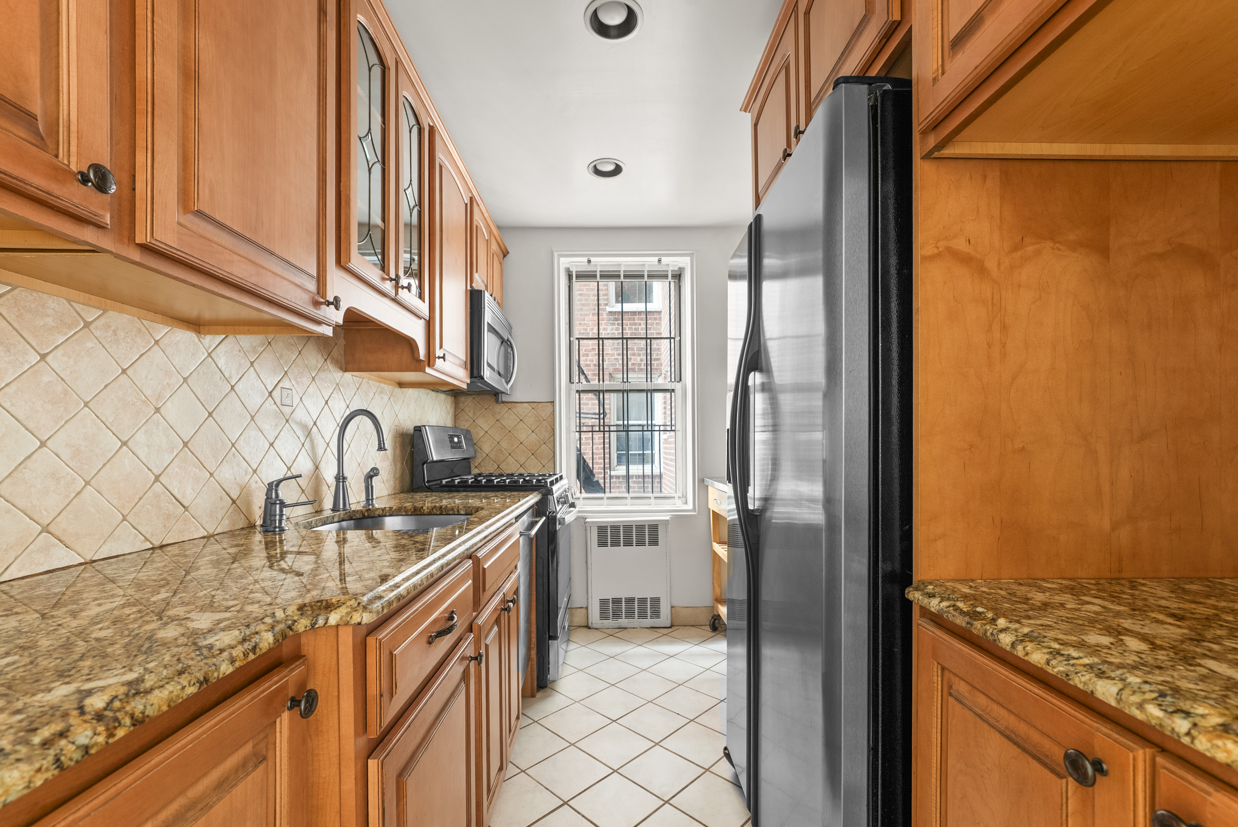 330 Haven Avenue, Unit 3G Manhattan, NY 10033 - Photo 5 of 7 a kitchen with stainless steel appliances granite countertop a refrigerator and a sink
