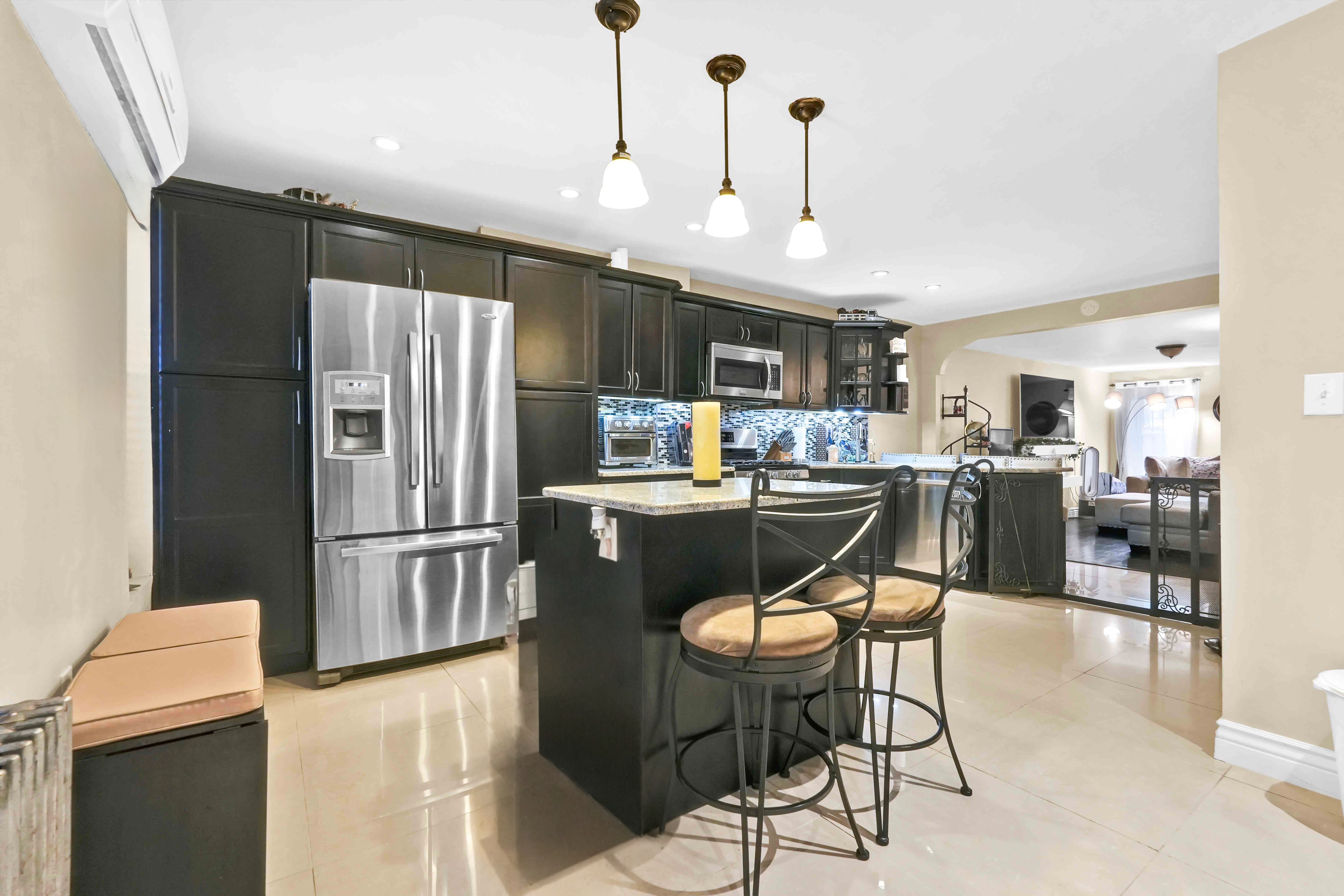 519 Monroe Street Brooklyn, NY 11221 - Photo 36 of 55 a kitchen with stainless steel appliances kitchen island granite countertop a refrigerator a stove a sink a table and chairs