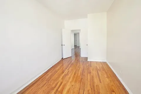 a view of a room with wooden floor and bench