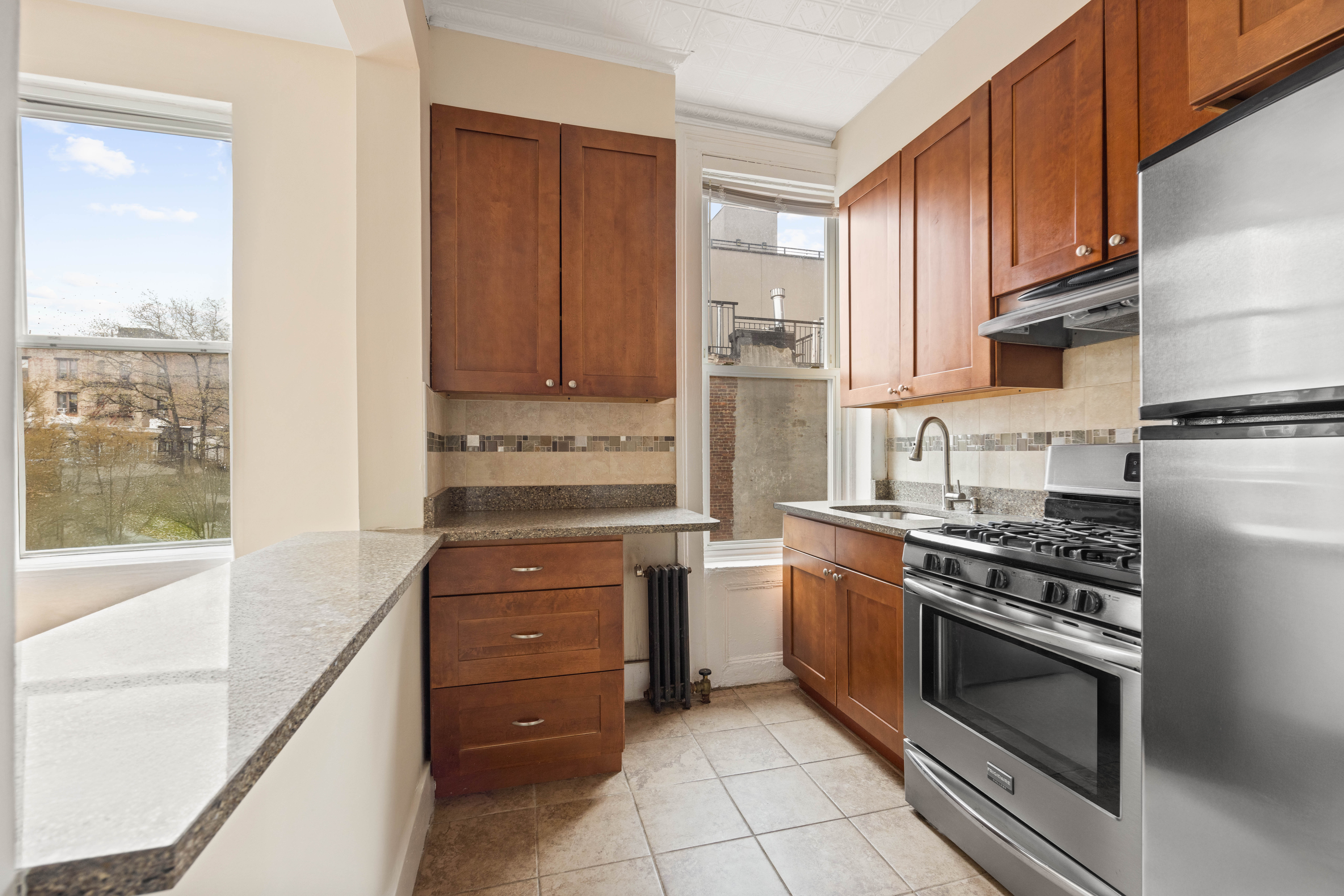 497 5th Avenue, Unit 3 Brooklyn, NY 11215 - Photo 2 of 5 a kitchen with stainless steel appliances granite countertop a stove and a refrigerator