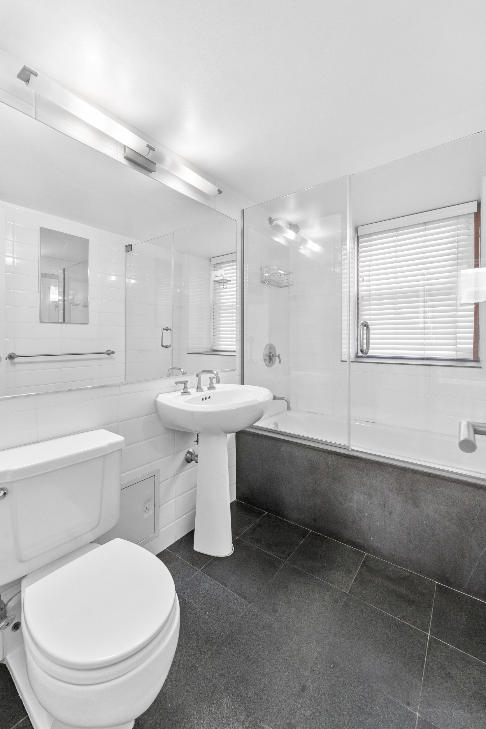 305 2nd Avenue, Unit 320 Manhattan, NY 10003 - Photo 8 of 16 a bathroom with a sink toilet a mirror and bathtub