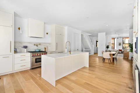 a large white kitchen with cabinets and chairs