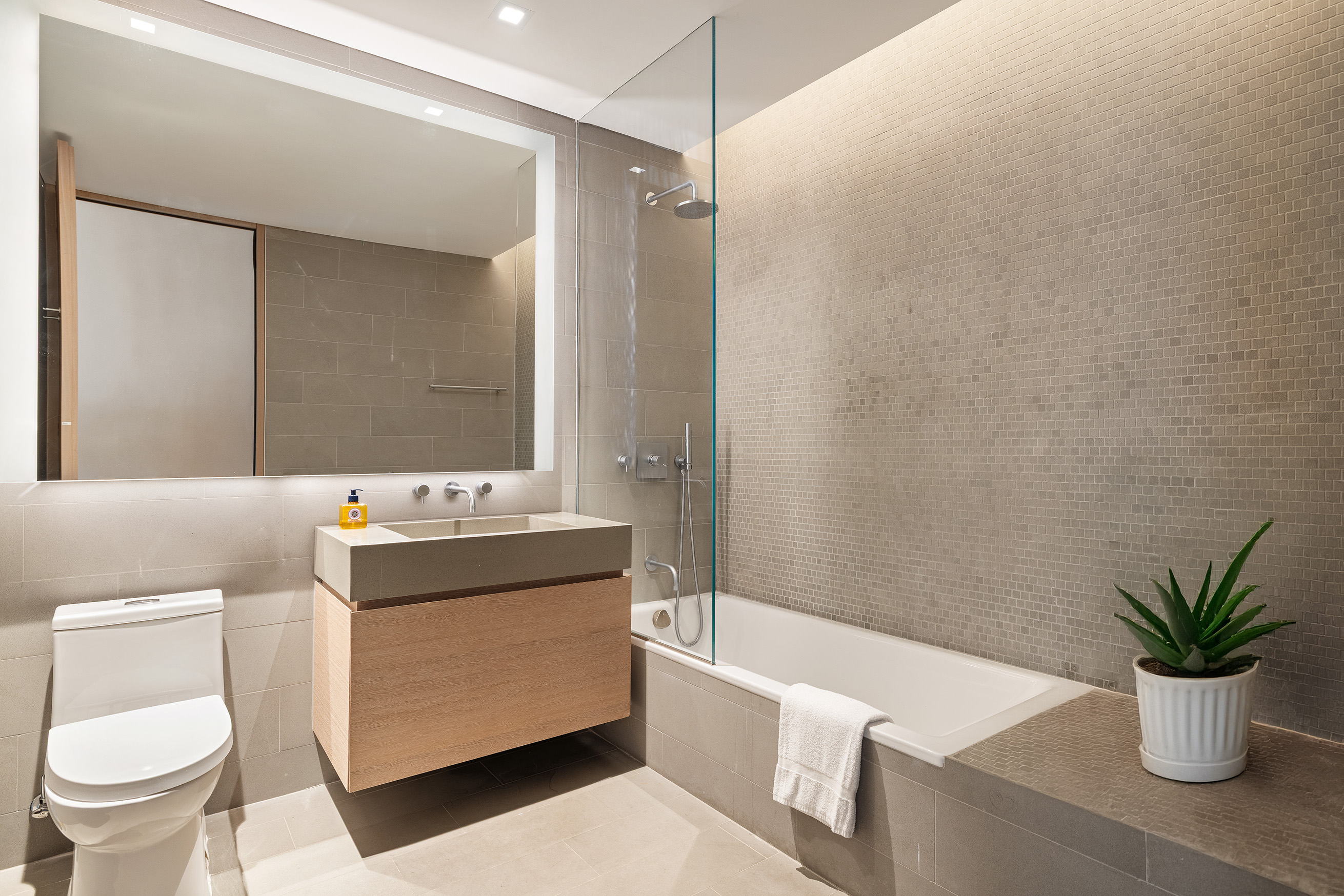 49 Chambers Street, Unit 17H Manhattan, NY 10007 - Photo 10 of 25 a bathroom with a bathtub sink mirror and toilet