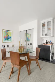 a living room with furniture and a dining table with wooden floor