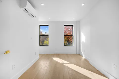 an empty room with wooden floor and window