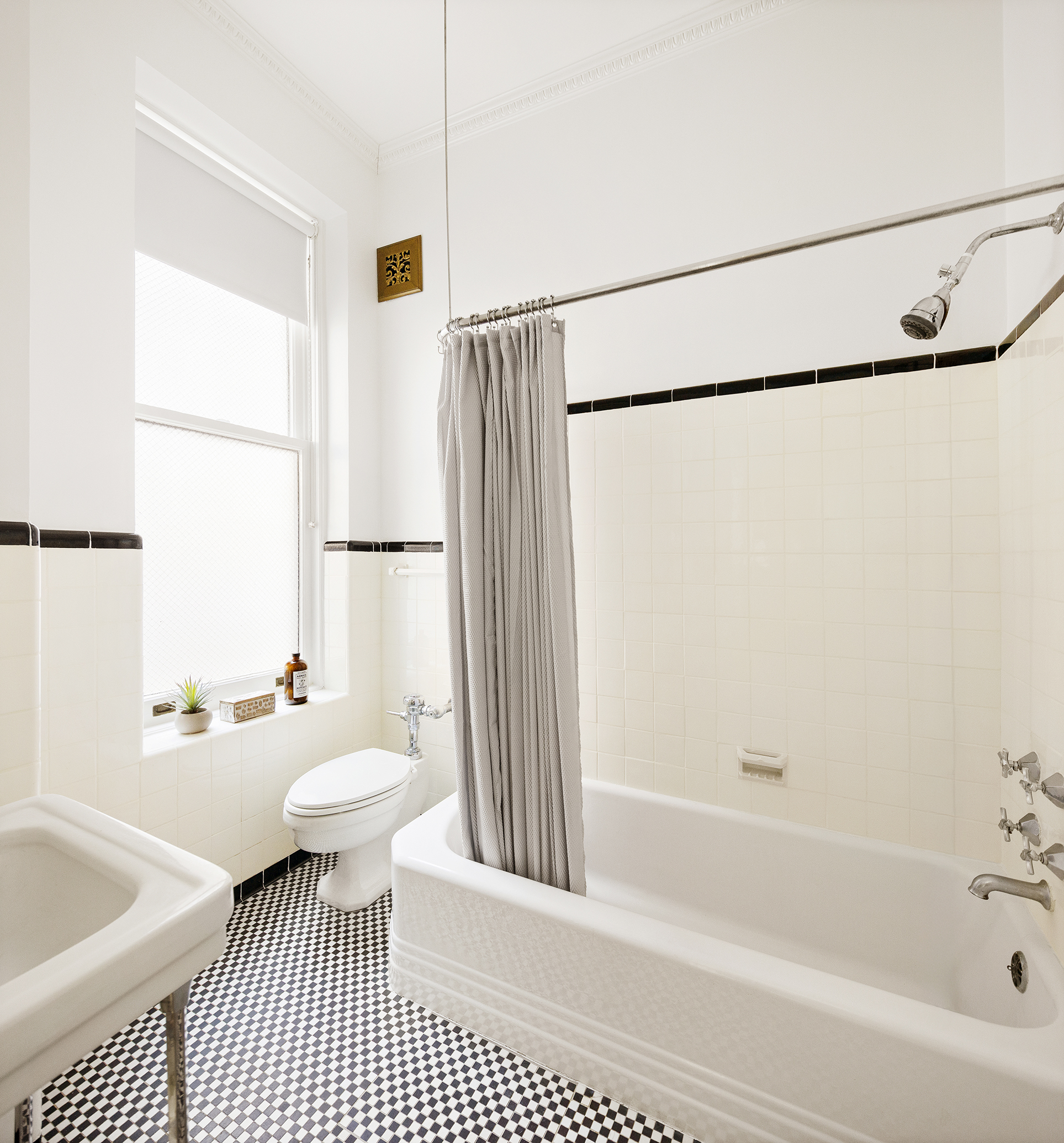 180 West 58th Street, Unit 5A Manhattan, NY 10019 - Photo 10 of 17 a bathroom with a sink a toilet a window and a shower