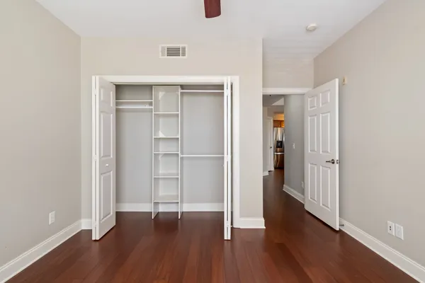an empty room with wooden floor & closet