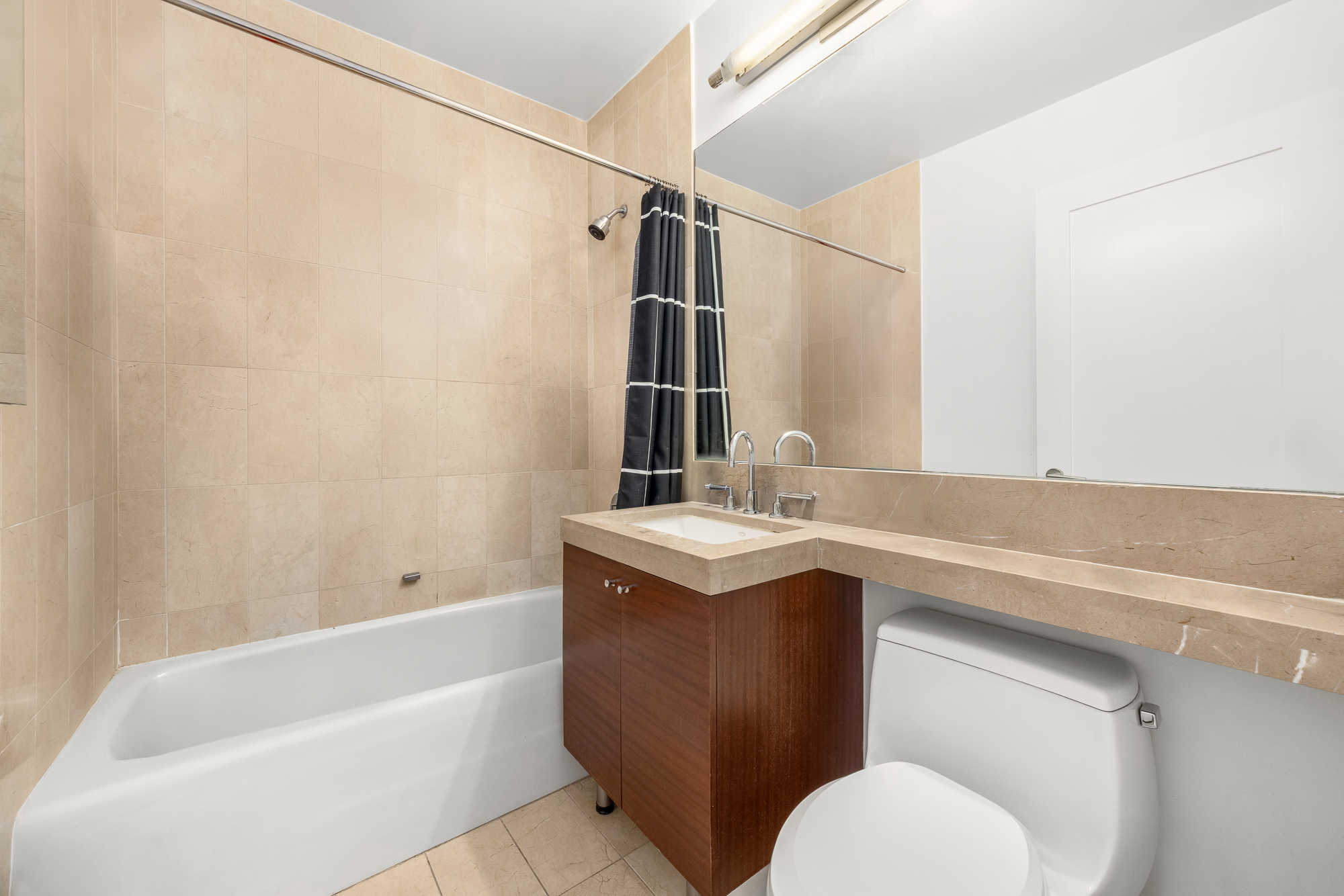 30 West Street, Unit 19A Manhattan, NY 10004 - Photo 9 of 12 a bathroom with a sink toilet and shower