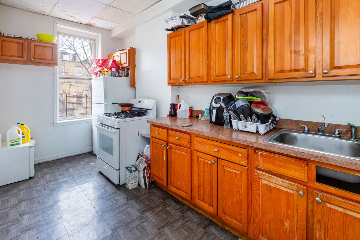 297 Pennsylvania Avenue Brooklyn, NY 11207 - Photo 5 of 9 a kitchen with granite countertop a sink cabinets stainless steel appliances and a window