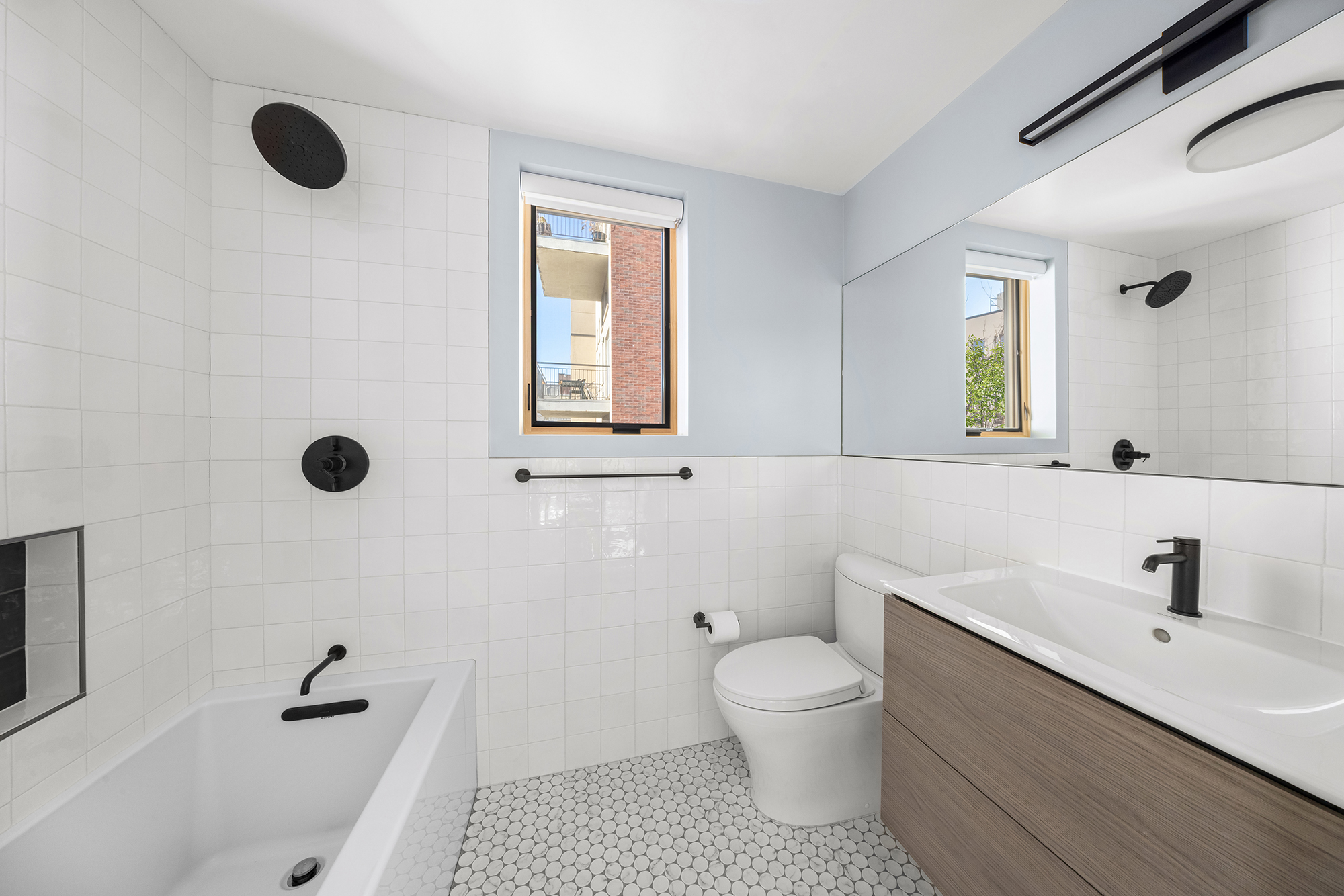 683 Leonard Street Brooklyn, NY 11222 - Photo 20 of 25 a bathroom with a toilet sink a mirror and shower