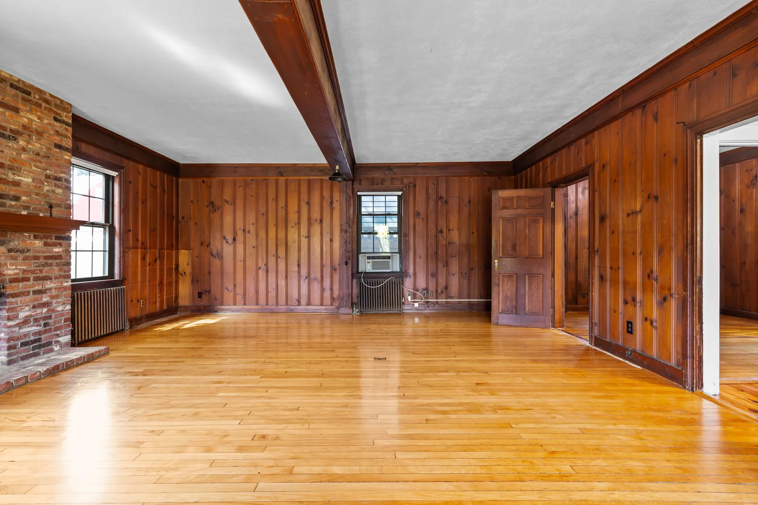 a view of an empty room with window and stairs