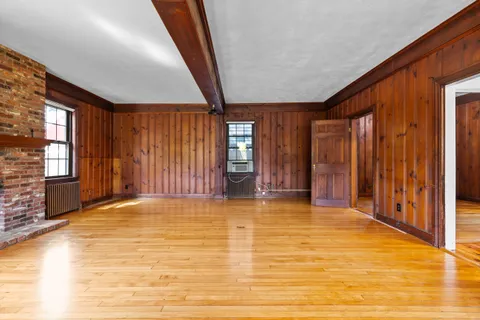 a view of an empty room with window and stairs