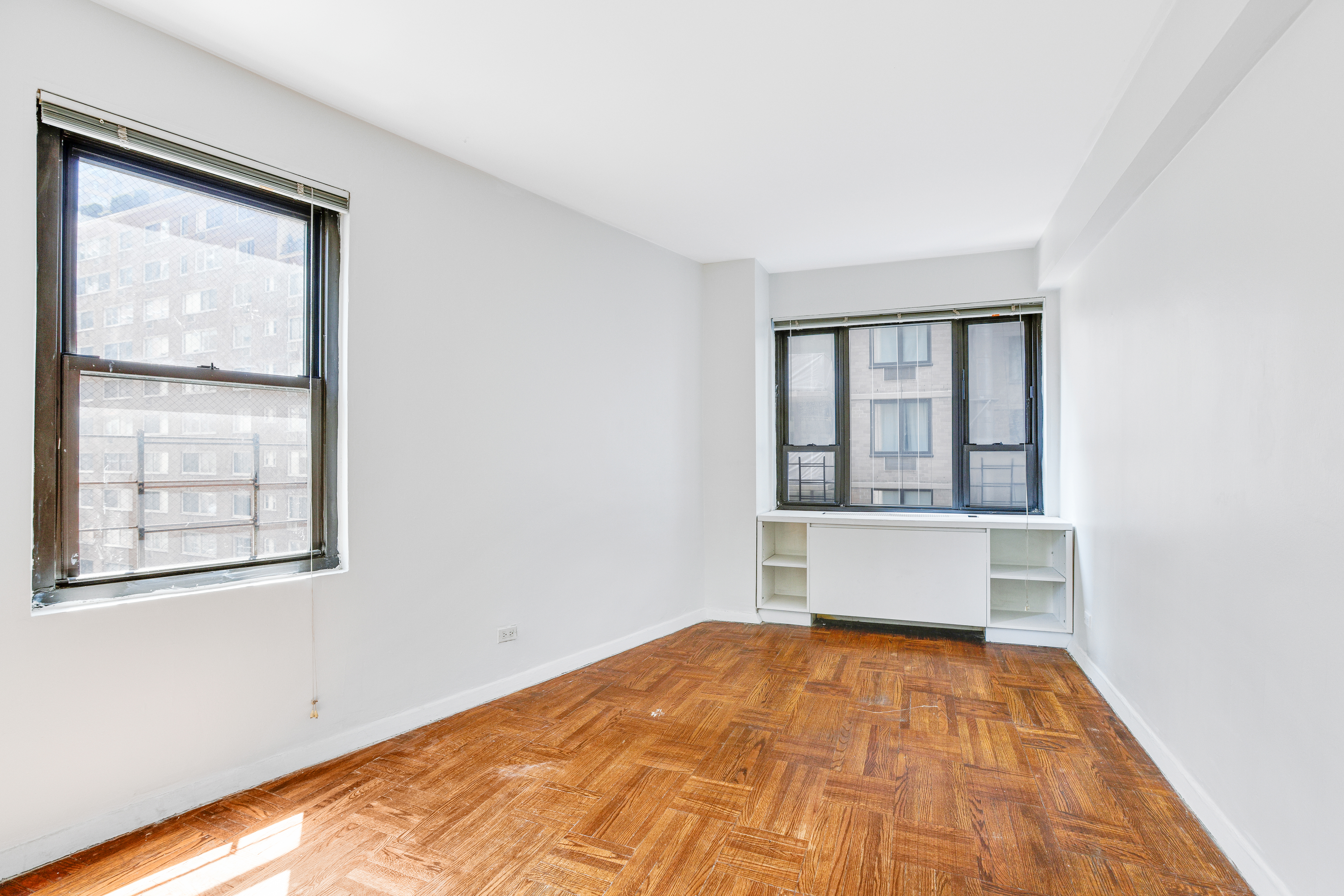 210 East 47th Street, Unit 7J Manhattan, NY 10017 - Photo 7 of 12 wooden floor in an empty room with a window