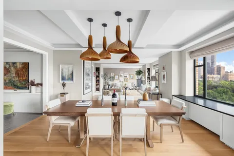 a dining room with furniture a chandelier and wooden floor