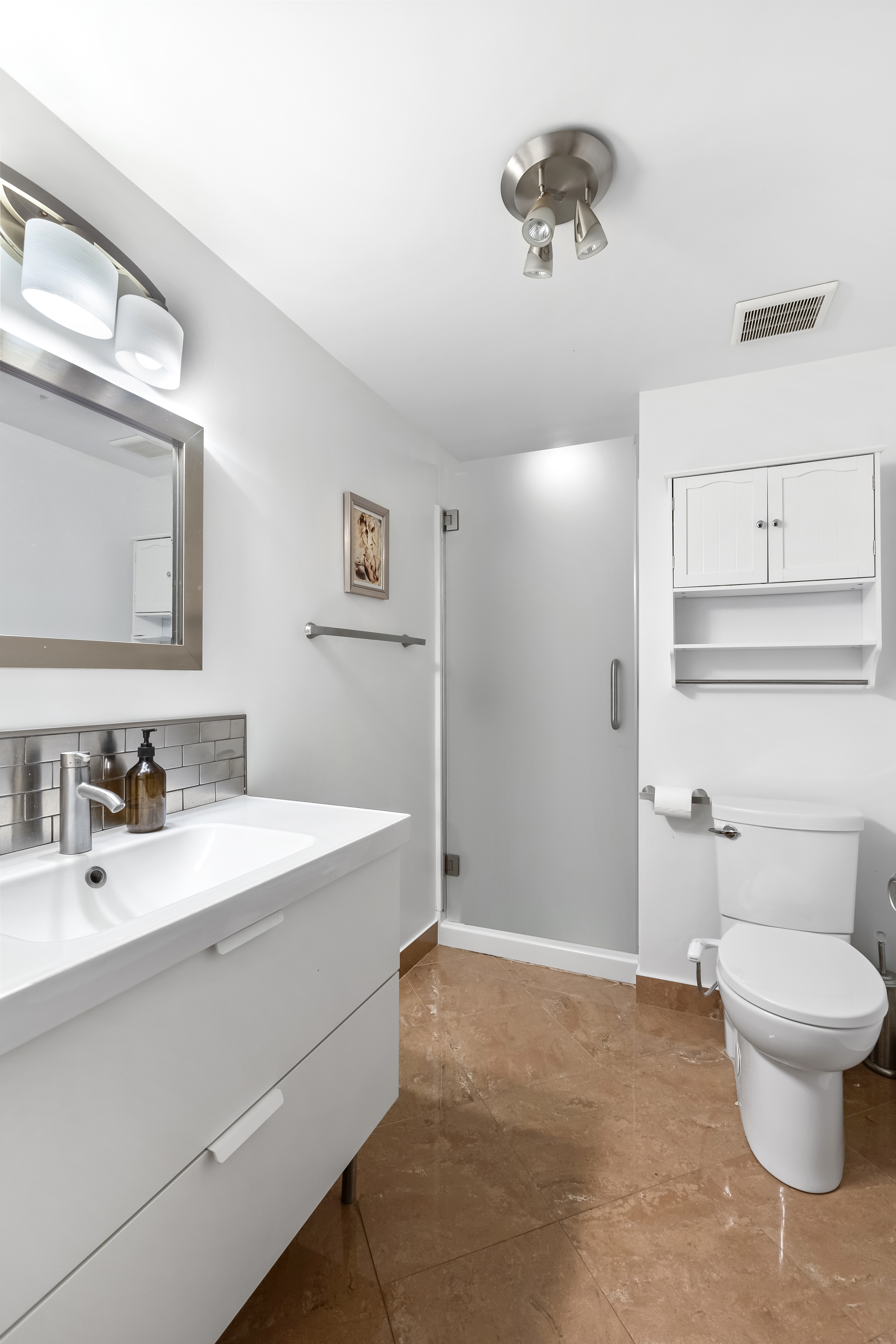 312 10th Street Brooklyn, NY 11215 - Photo 16 of 17 a bathroom with a sink a toilet and a mirror
