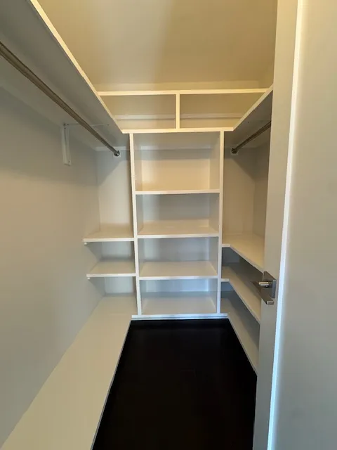 a view of walk in closet with empty racks