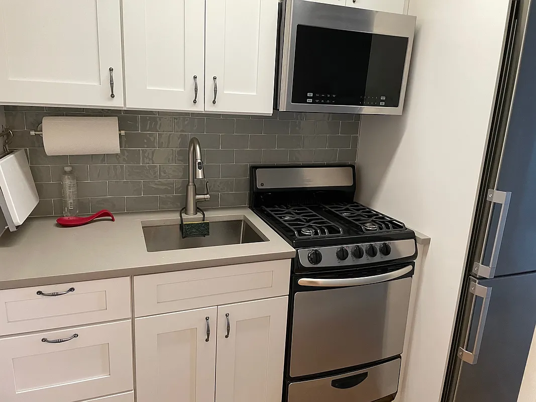 433 West 34th Street, Unit 7B Manhattan, NY 10001 - Photo 6 of 13 a kitchen with a stove and a microwave
