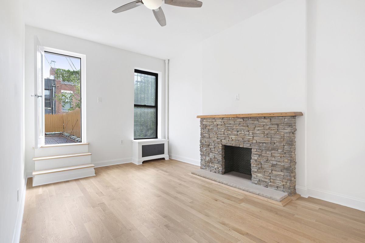 an empty room with windows and fireplace