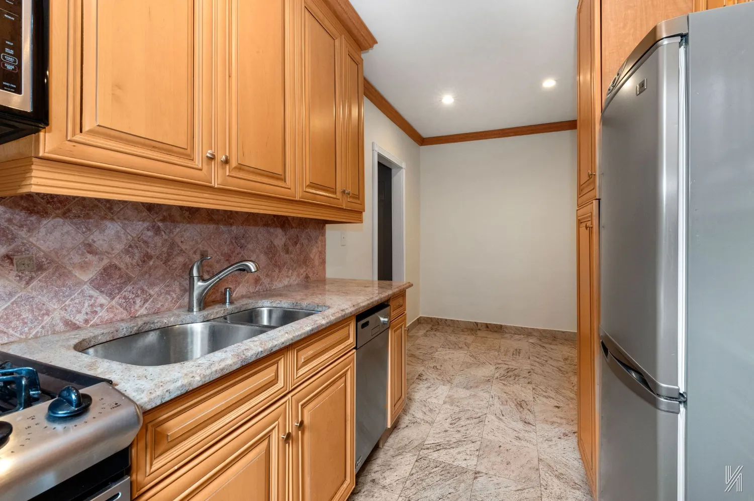 a kitchen with stainless steel appliances granite countertop a sink and a refrigerator
