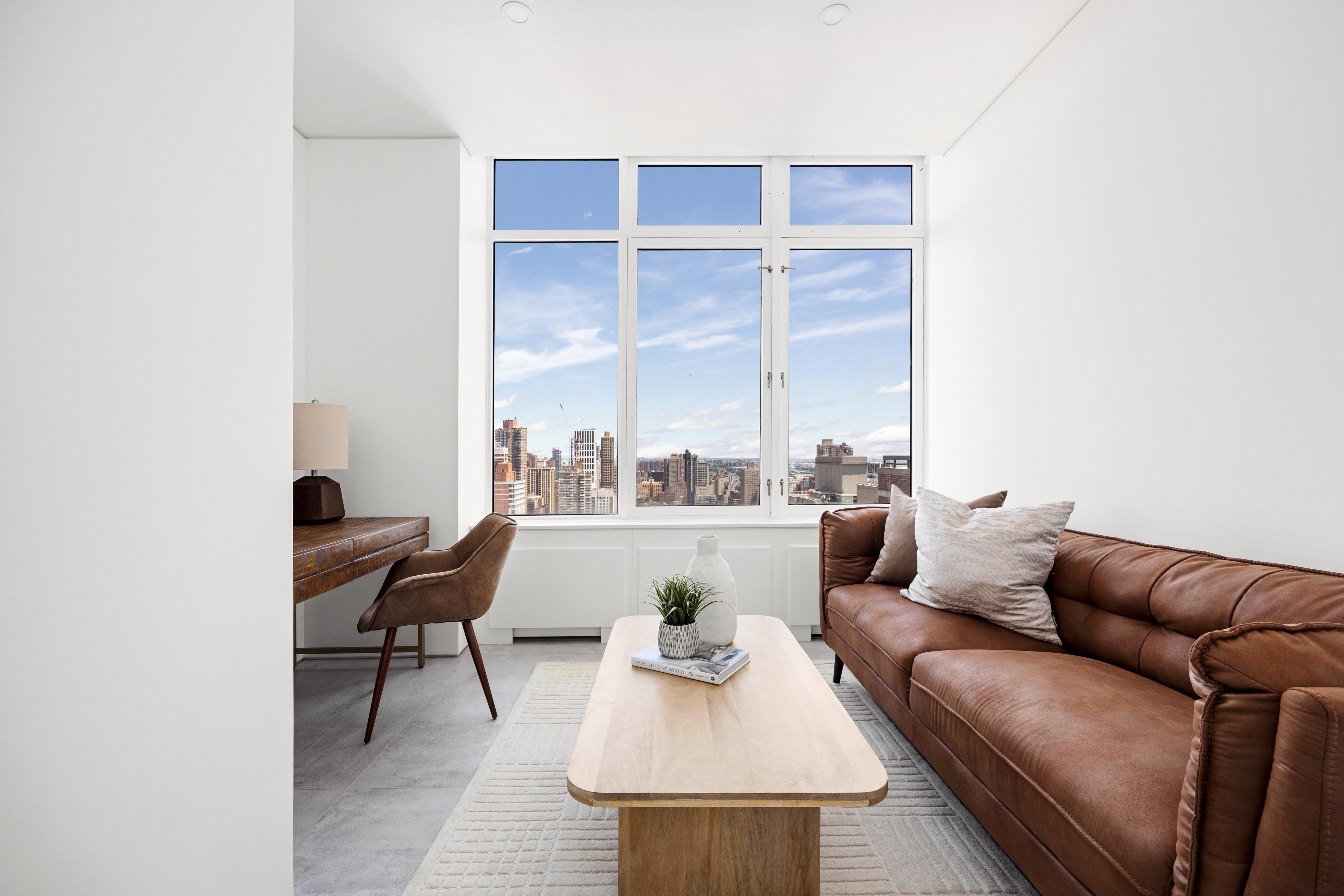 422 East 72nd Street, Unit 37AD Manhattan, NY 10021 - Photo 25 of 38 a living room with furniture and a lamp