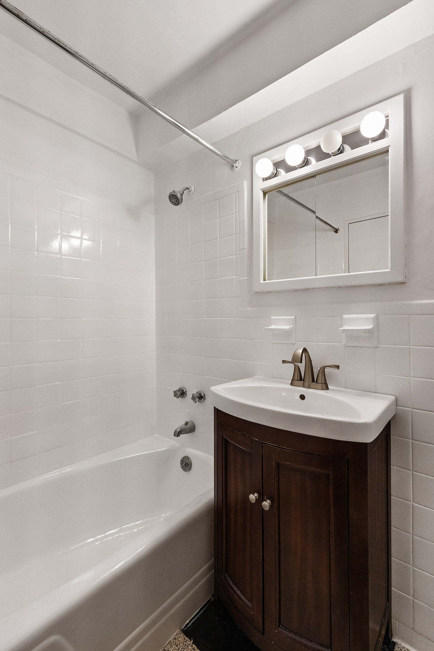 335 East 51st Street, Unit 3H Manhattan, NY 10022 - Photo 8 of 11 a bathroom with a sink a bathtub and a mirror