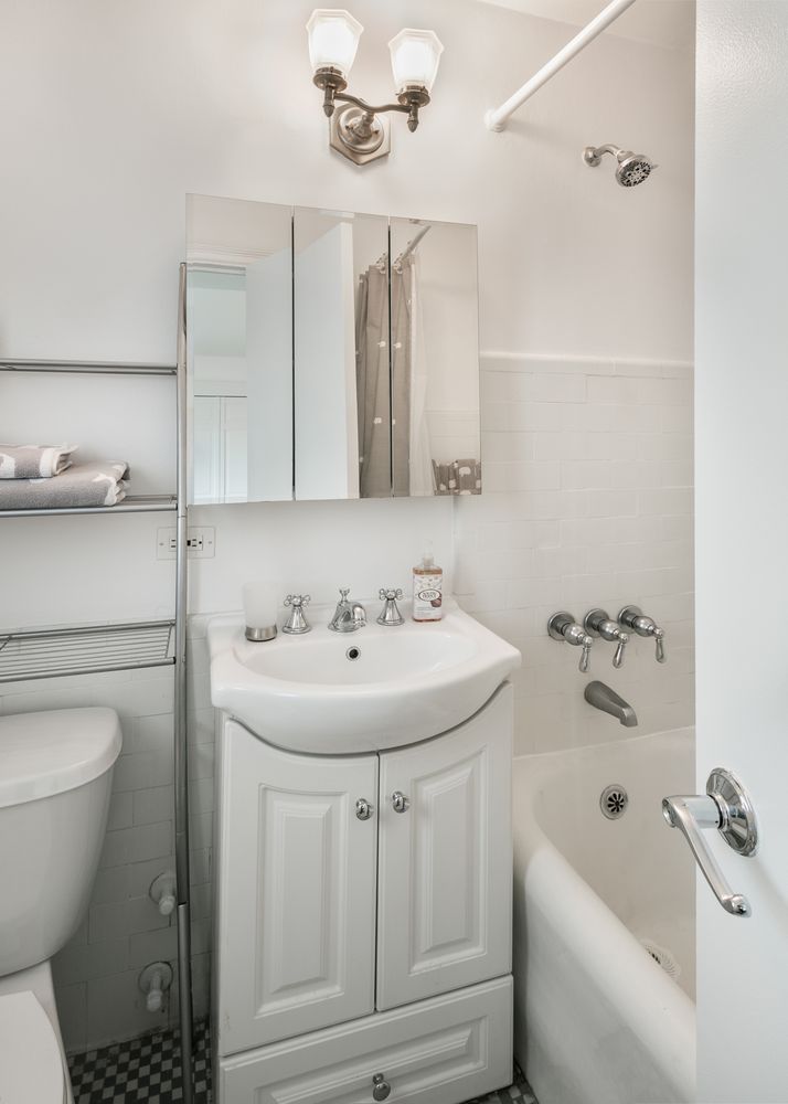 5 Tudor City Place, Unit 2122 Manhattan, NY 10017 - Photo 3 of 8 a bathroom with a sink a toilet and shower