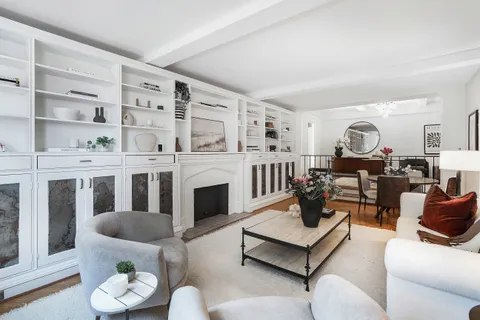 a living room with furniture kitchen view and a window