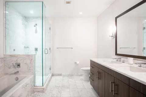a bathroom with a sink a toilet and shower