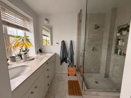 a bathroom with a granite countertop sink a mirror and shower