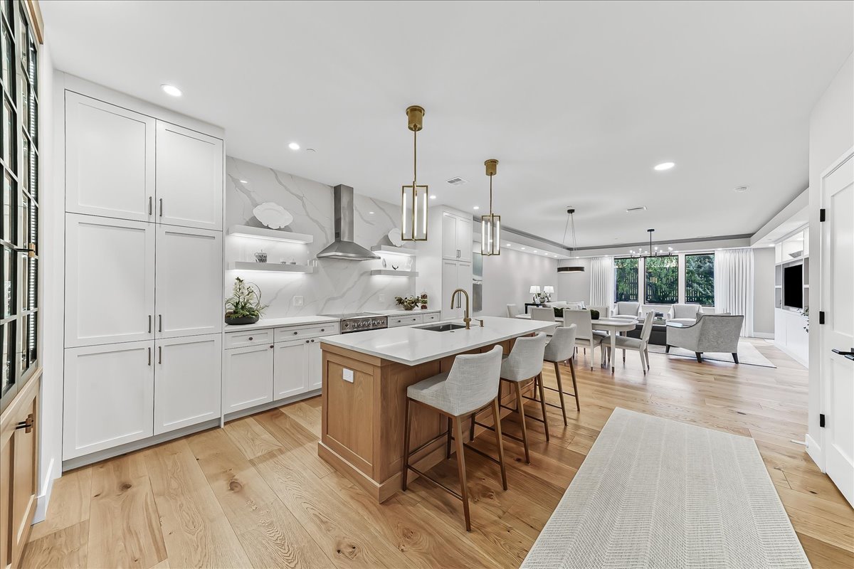 a kitchen with white cabinets and chairs