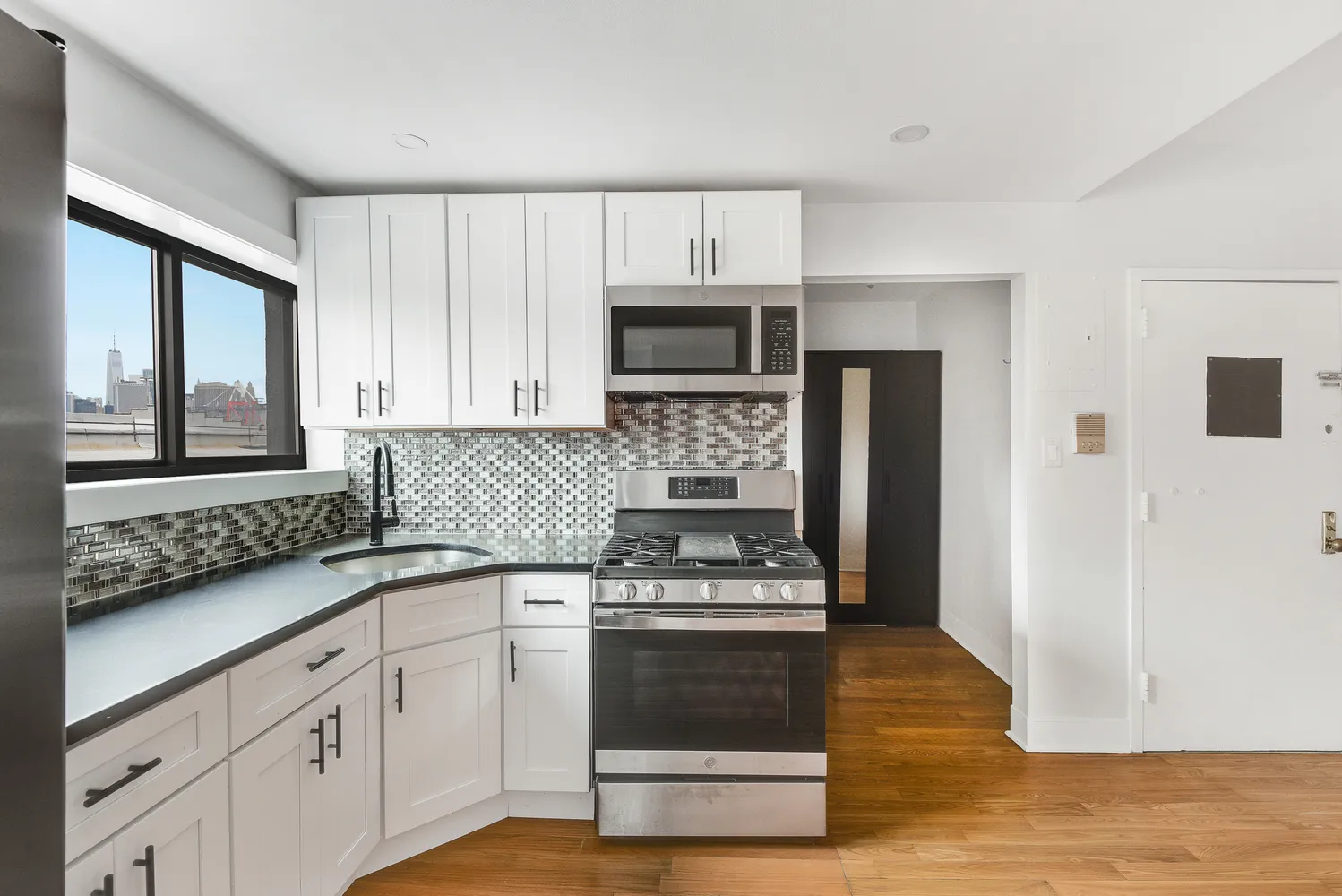 a kitchen with granite countertop a stove a sink and a refrigerator