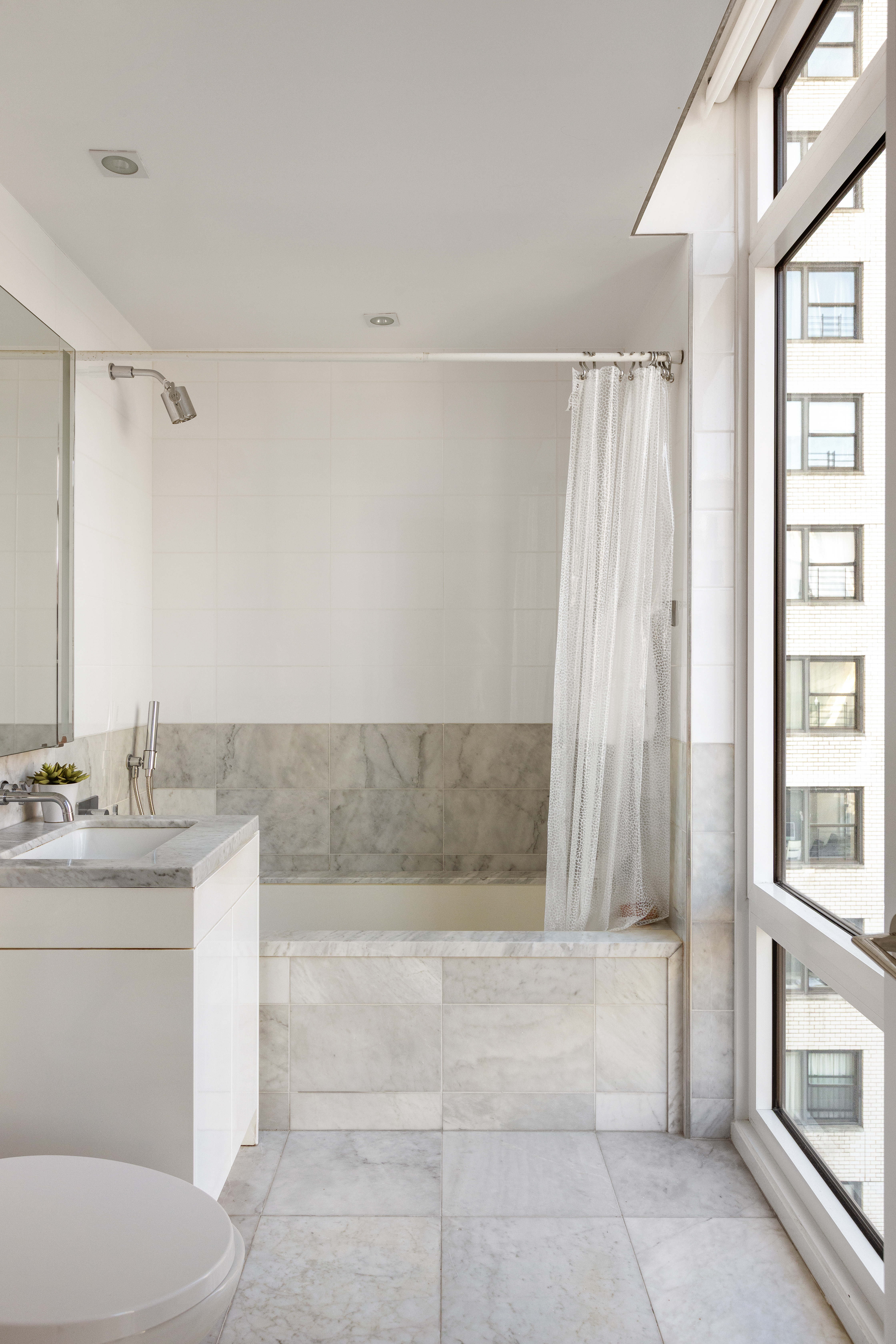 1355 1st Avenue, Unit 8 Manhattan, NY 10021 - Photo 21 of 25 a bathroom with a granite countertop sink a toilet and bathtub