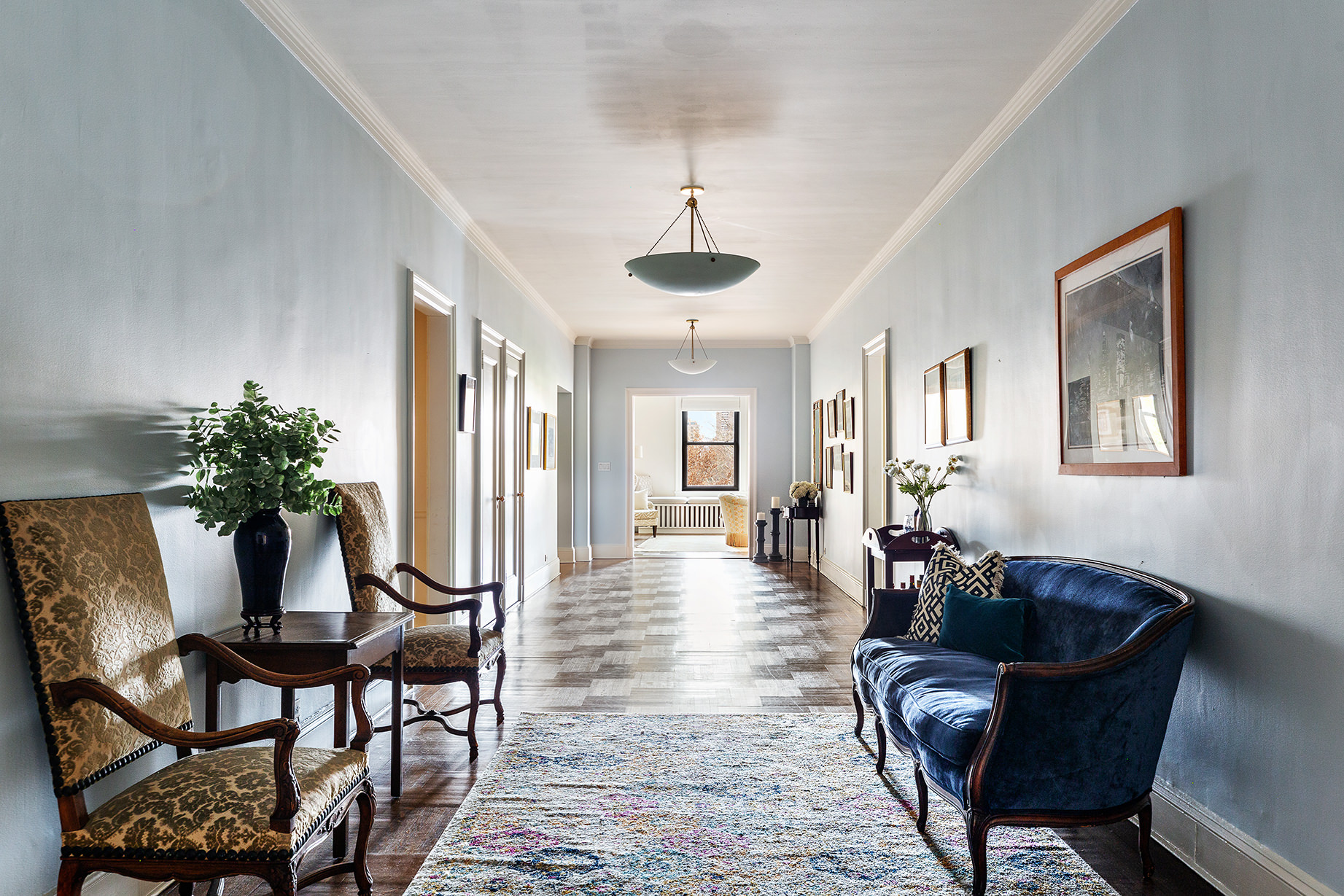 1115 5th Avenue, Unit 5B Manhattan, NY 10128 - Photo 16 of 19 a living room with furniture a chandelier and a rug
