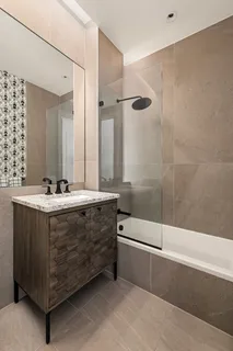 a bathroom with a double vanity sink a mirror and a bathtub