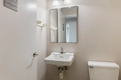a bathroom with a sink a toilet and mirror