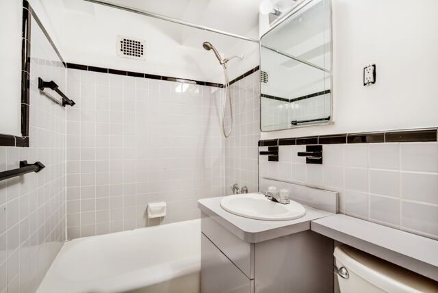 320 East 54th Street, Unit 4A Manhattan, NY 10022 - Photo 4 of 5 a bathroom with a sink a vanity and shower