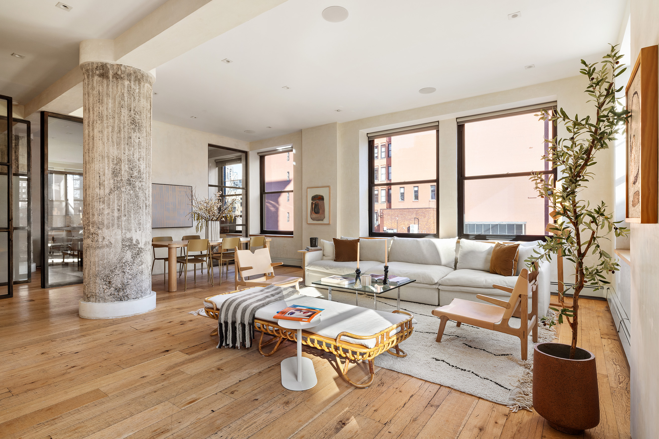 a living room with furniture large window and wooden floor