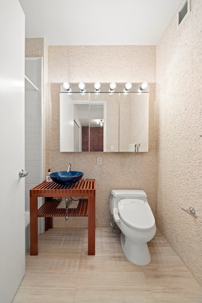 252 7th Avenue, Unit 10T Manhattan, NY 10001 - Photo 9 of 10 a bathroom with a toilet a sink and a mirror