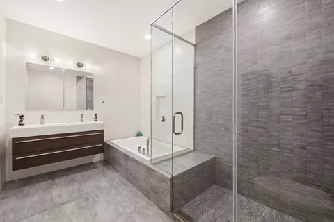 a bathroom with a bathtub a shower and a sink