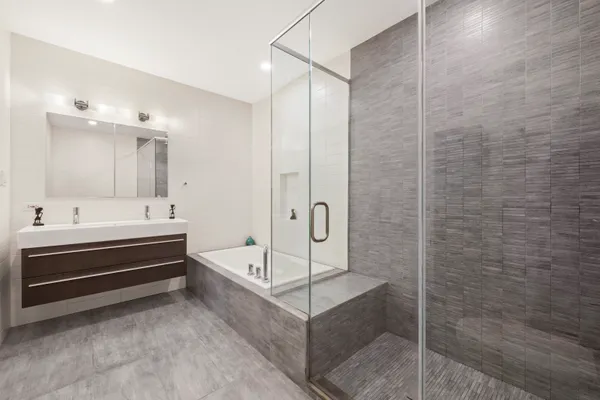 a bathroom with a bathtub a shower and a sink