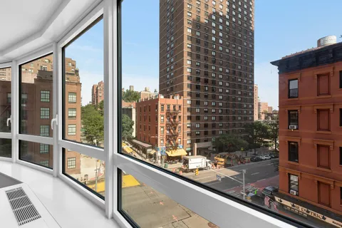 a view of a balcony with a floor to ceiling window next to a tall building