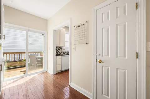 a view of a hallway with wooden floor and cabinet