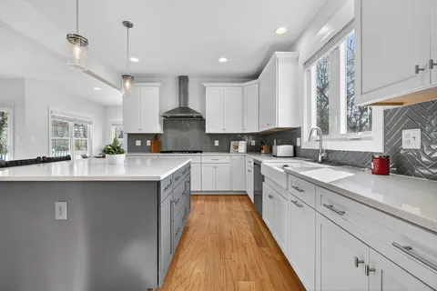a large kitchen with stainless steel appliances kitchen island granite countertop a sink and cabinets