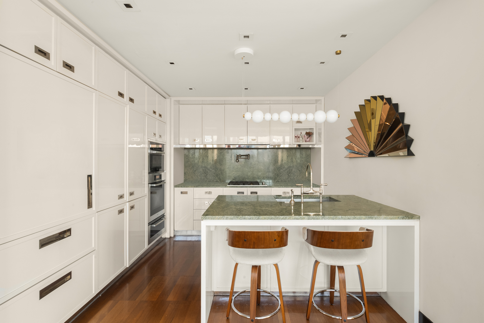 151 East 85th Street, Unit 17B Manhattan, NY 10028 - Photo 6 of 10 a kitchen with stainless steel appliances kitchen island granite countertop a table and chairs