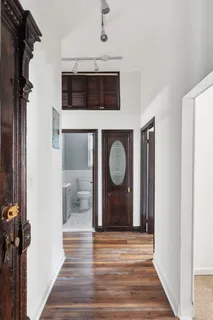 a view of a hallway with wooden floor and staircase