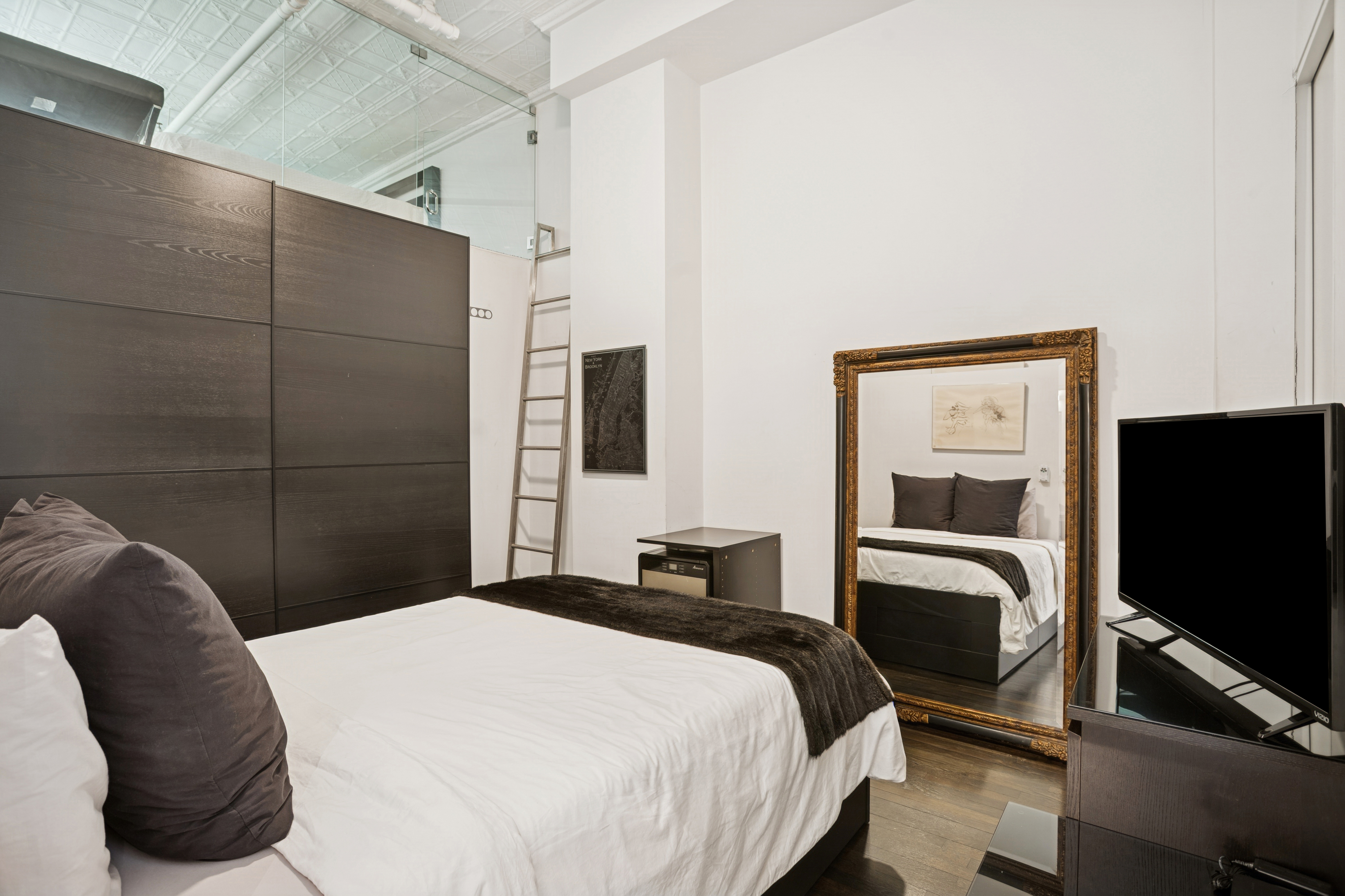 716 Broadway Manhattan, NY 10003 - Photo 12 of 15 a bedroom with a bed and a flat screen tv